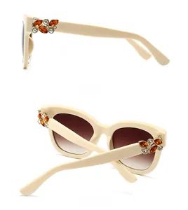 Détail des lunettes de soleil oversize beige avec strass vues de côté et de l'arrière