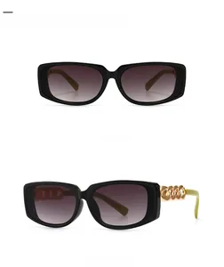 Detail of square black sunglasses with grey gradient lenses and gold chain temples