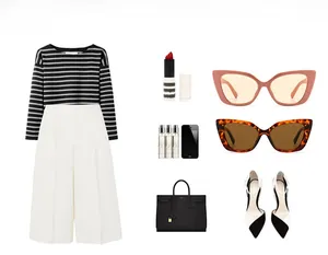 Flat lay of cat-eye sunglasses with striped top, high-waist pants and stylish accessories