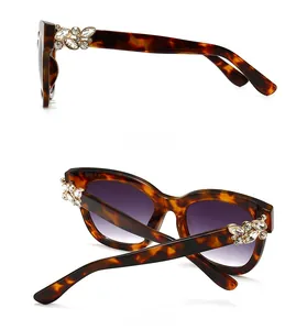Détail de lunettes de soleil écaillées avec verres dégradés violets et strass sur branches