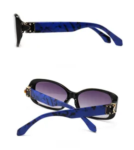 Detail view of square sunglasses featuring blue marble pattern temples and gold accents
