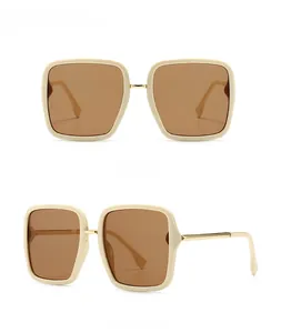 Detail view of beige frame sunglasses with tan lenses and gold metal accents