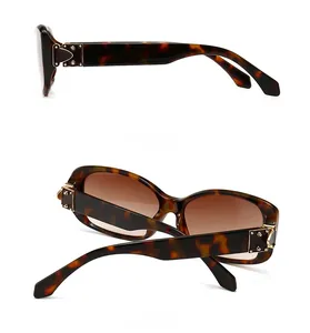 Detail view of tortoiseshell sunglasses showing gold metal hinges and side profile