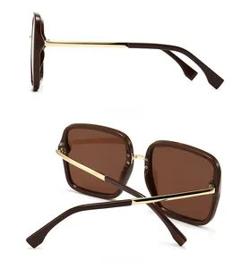 Detail view of square sunglasses with gold metal temples and geometric cut-out tips