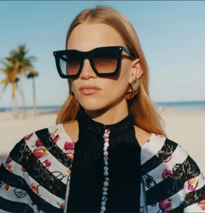 Détail de lunettes de soleil carrées noires avec verres dégradés sur un modèle