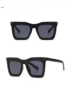 Vue avant et latérale de lunettes de soleil carrées avec rivets dorés et verres noirs