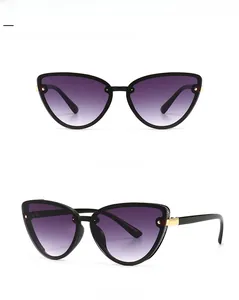 Detail view of black cat-eye sunglasses with purple gradient lenses and gold accents