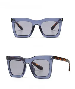 Détail de lunettes de soleil carrées avec monture bleue et branches en écaille de tortue