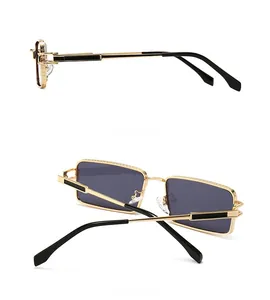 Detail view of gold rectangle sunglasses featuring black temple accents and metal engraving