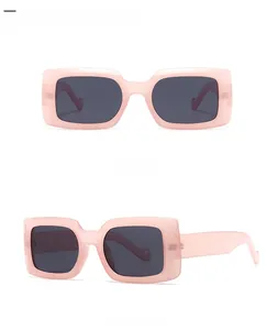Détail de lunettes de soleil carrées roses avec verres gris foncé en vue de face et de profil