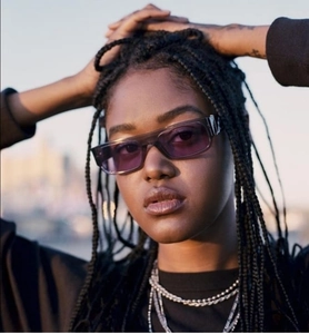 Close-up of trendy square sunglasses with purple lenses and chunky silver necklaces