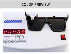 Close-up of black oversized sunglasses showing UV400 protection test on professional device