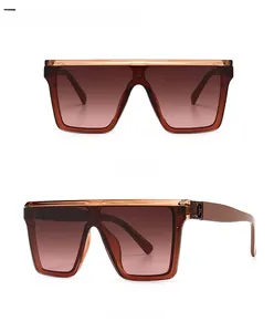 Detail view of flat top square sunglasses with tea-pink gradient lenses and gold hinge logo