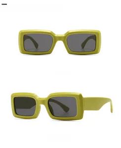 Detail view of avocado green rectangle sunglasses with dark grey lenses and chunky frame