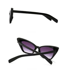 Detail view of narrow retro cat eye sunglasses with purple gradient lenses and black frame