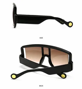 Detail view showing side and back of wide-temple oversized sunglasses with gold rivets