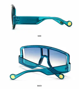 Detail view of teal mask sunglasses with gradient lenses and gold rivet accents on wide temples