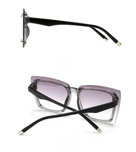 Detail view of square sunglasses featuring purple gradient lenses and silver temple accents