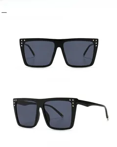 Detail of square oversized sunglasses featuring black glossy frames and silver stud accents
