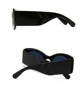 Detail view of bold black sunglasses with wide temples and dark blue lenses