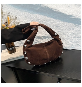 Detailed shot of dark brown suede vintage handbag with silver metal ball studs