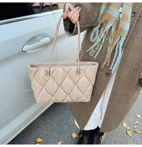 Macro shot of beige quilted tote bag showing diamond stitching detail and soft leather texture