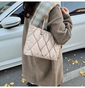 Close-up of quilted beige tote bag with rhombus stitching in a cozy autumn street setting
