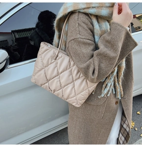 Close-up of beige quilted tote bag showing rhombus stitching and soft matte texture