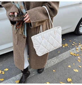 Close-up of quilted white tote bag with diamond stitching and puffer texture for winter