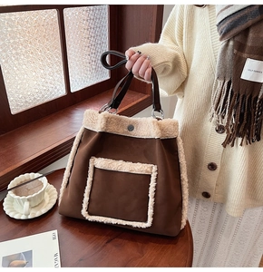 Detailed close-up of brown plush shoulder bag with fuzzy white trim and faux suede texture