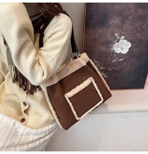 Detailed view of the brown fabric shoulder bag with cream lamb wool trim and front pocket