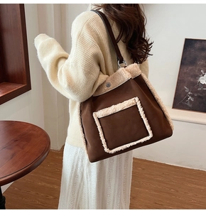 Detail of brown suede tote bag with plush lamb wool trim and leather shoulder strap