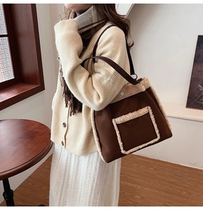 Detail of plush faux shearling trim and brown suede shoulder bag for winter fashion