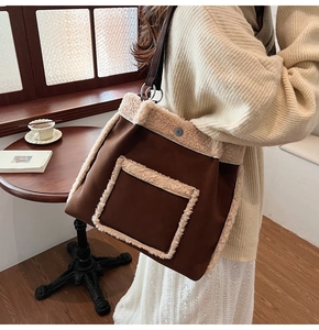 Detail of large brown fabric tote bag with cream fleece trim and metal magnetic closure