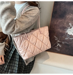 Detail of soft quilted pink tote bag with diamond pattern stitching and slim straps