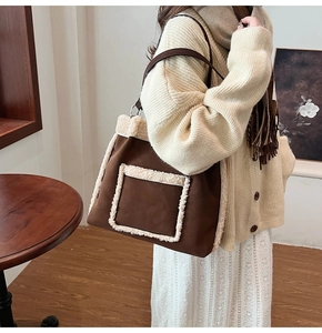 Brown faux suede tote bag with white faux shearling trim shown in a warm lifestyle setting