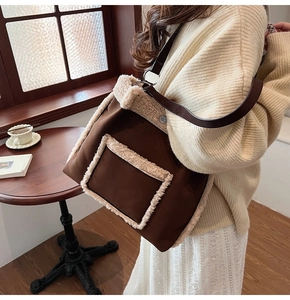 Detail of plush lamb wool trimming on deep brown suede tote bag with leather strap