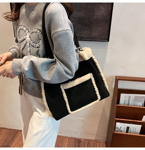 Detail of a black and beige faux shearling tote bag with a front flap pocket and shoulder strap