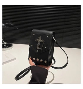 Detailed view of black gothic crossbody bag featuring a metal cross and silver star studs