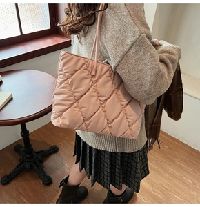 Quilted tote bag in nude pink showing large diamond stitching and rope handles