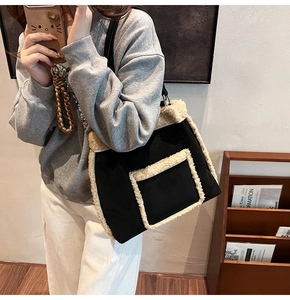 Close-up of black canvas tote bag with cream fleece trim and outer pocket detail