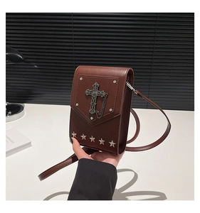 Detail of vintage brown PU leather mini bag with silver cross and star rivets