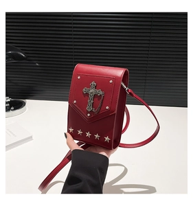 Detail of dark red gothic crossbody bag with silver cross chain and star rivets