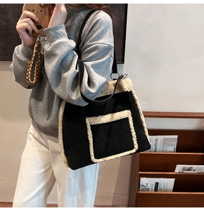 Detail of the black faux suede tote bag with plush cream fleece trim and shoulder strap