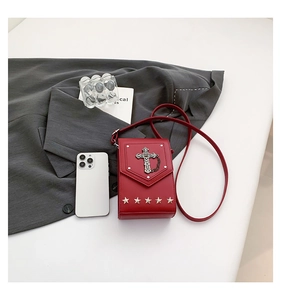 Detail of red punk crossbody phone bag featuring silver cross and star studs decoration