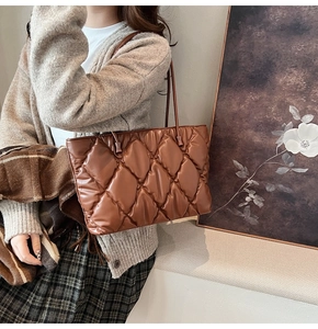 Close-up of caramel quilted tote bag with diamond lattice pattern and leather straps