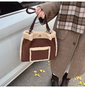 Detail of faux shearling trim and brown leather texture on a spacious autumn tote bag