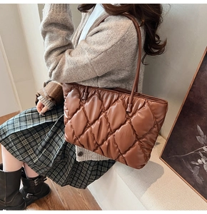 Close-up of brown quilted bubble tote bag featuring glossy leather and soft textures