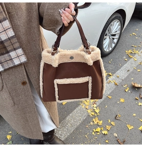 Detail of faux shearling trim on brown suede tote bag with leather straps for autumn