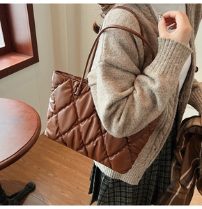 Close-up of brown quilted tote bag showing premium PU leather texture and stitching